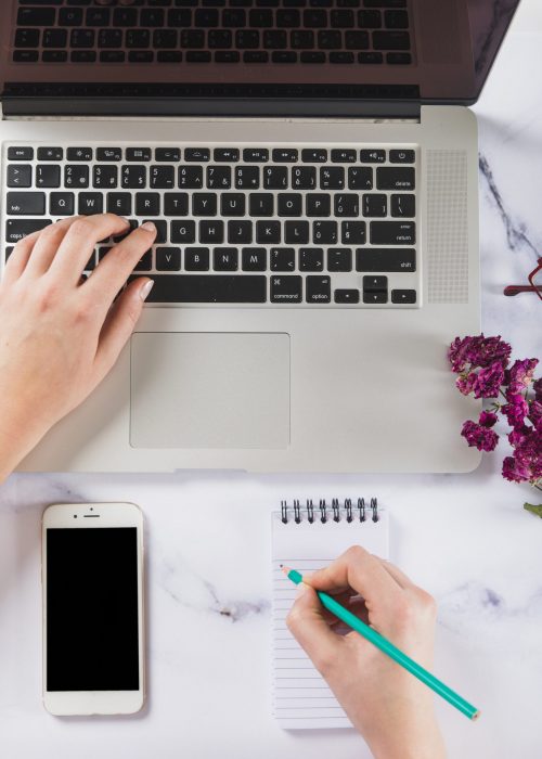 crop-hands-using-laptop-making-notes